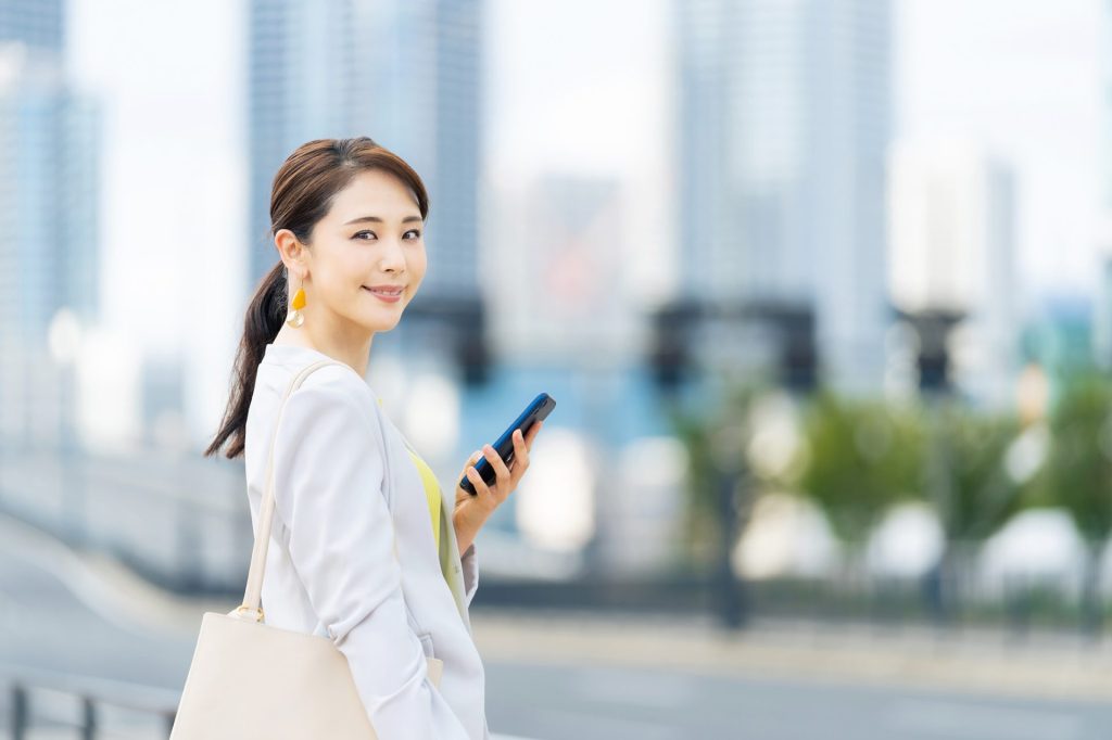 スマートフォンを持って振り返る女性